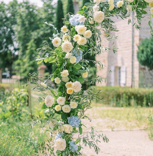 Arche florale élegante en roses crèmes et hortensias bleus
