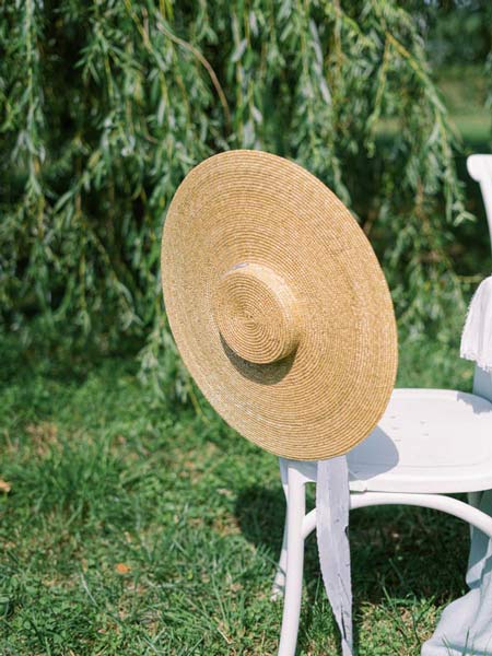 Chapeau de paille d'arlésienne sur une chaise, dans un jardin